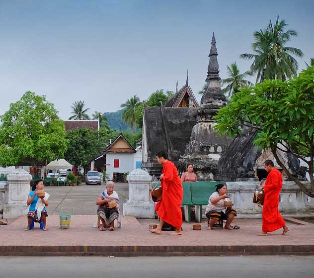 Laos luang prabang people give food and sticky rice to monks for merit time on early morning