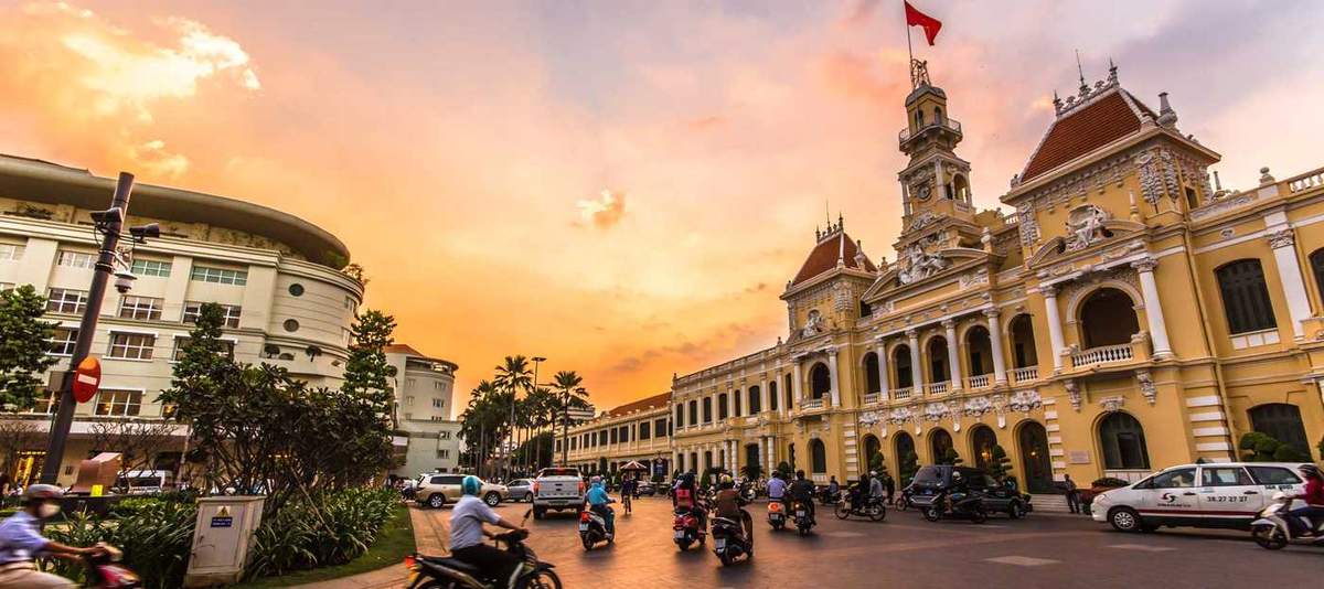 Vietnam saigon traffic in front of ho chi minh city hall at twilight