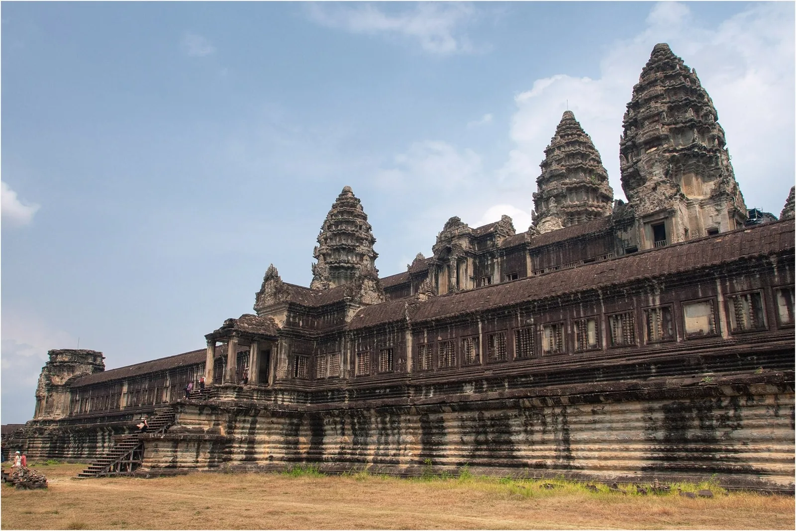 The stone towers and long galleries of Angkor Wat rise against a blue sky in Siem Reap.