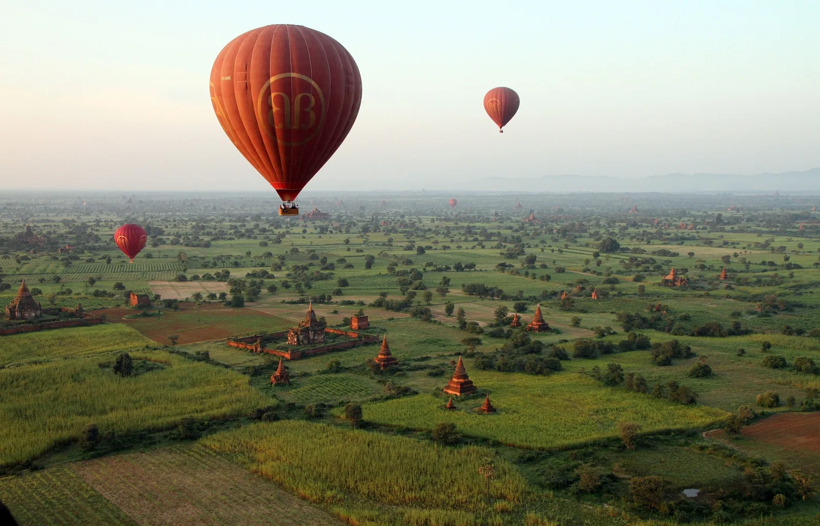 Hot air balloons drift over the temple-studded plains of Bagan at dawn.