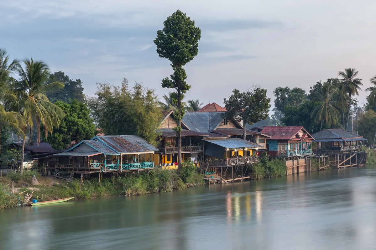 Wooden stilt houses line the Mekong riverbank on Don Det island in Si Phan Don, Laos.