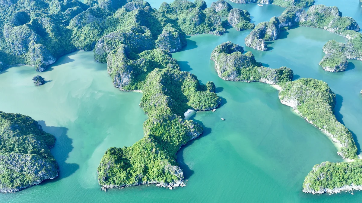Aerial view of limestone karst islands scattered across turquoise waters in Halong Bay, Vietnam.